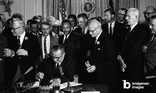 CIVIL RIGHTS LAW, 1964 President Lyndon B. Johnson signs the Civil Rights Act of 1964 as Martin Luther King, Jr. and others look on. Photograph by Cecil Stoughton, 2 July 1964. / Granger / Bridgeman Images